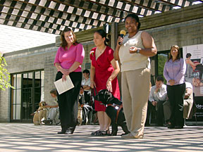 Instructor, graduate, lab in harness, and puppy raiser on stage