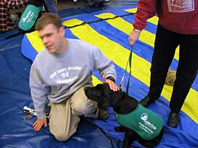 Cynthia receiving a pet on the head from a teenage blind student